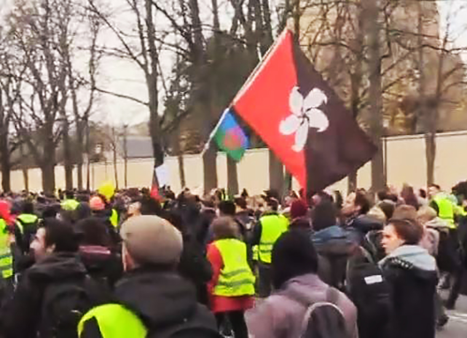 Gelbwesten in Paris mit der Hongkonger Flagge (schwarzrote Version)